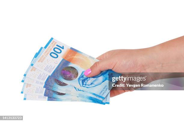 woman's hand giving swiss franc bills, isolated on white background - franken stock-fotos und bilder