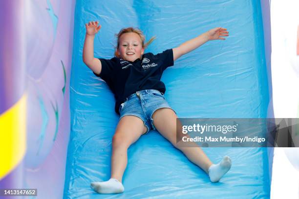 Mia Tindall plays on a bouncy slide as she attends day 1 of the 2022 Festival of British Eventing at Gatcombe Park on August 5, 2022 in Stroud,...