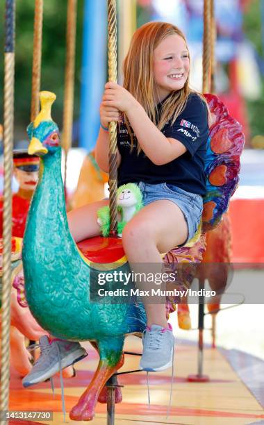 Mia Tindall rides on a carousel as she attends day 1 of the 2022 Festival of British Eventing at Gatcombe Park on August 5, 2022 in Stroud, England.