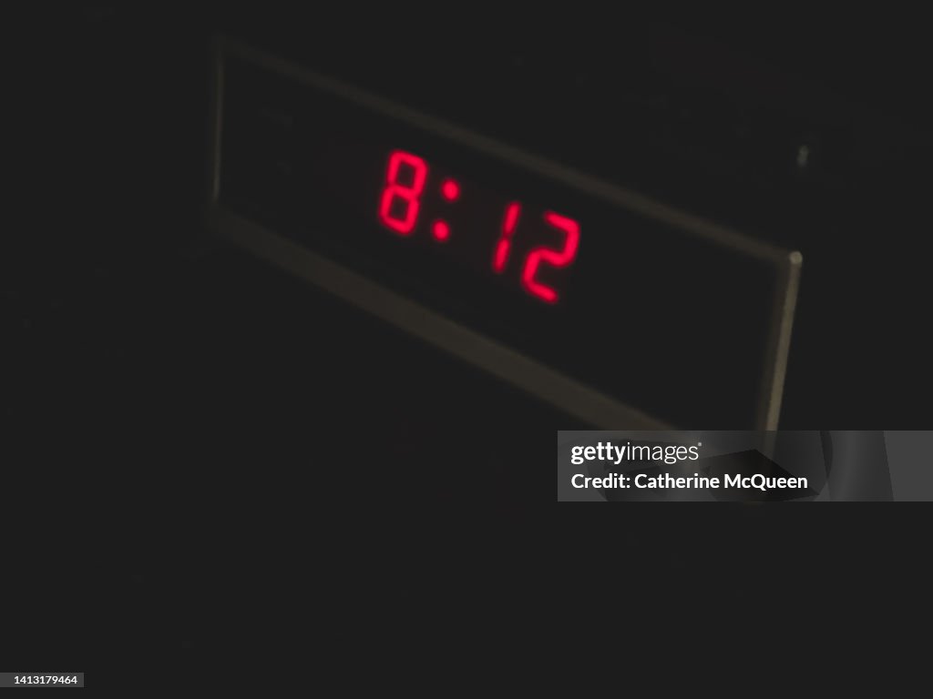 Retro digital alarm clock in dark room