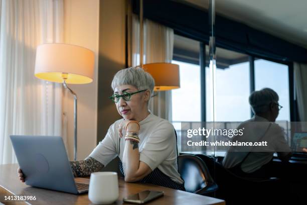 asian senior woman at home using laptop - old woman tattoos stock pictures, royalty-free photos & images