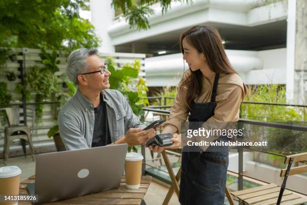 asian young entrepreneurs are serving customers - royalty payment stock pictures, royalty-free photos & images