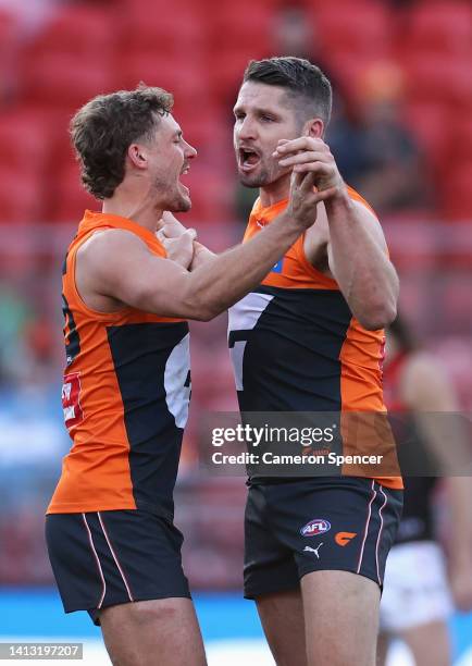 Jesse Hogan of the Giants celebrates kicking a goal with Harry Perryman of the Giants during the round 21 AFL match between the Greater Western...