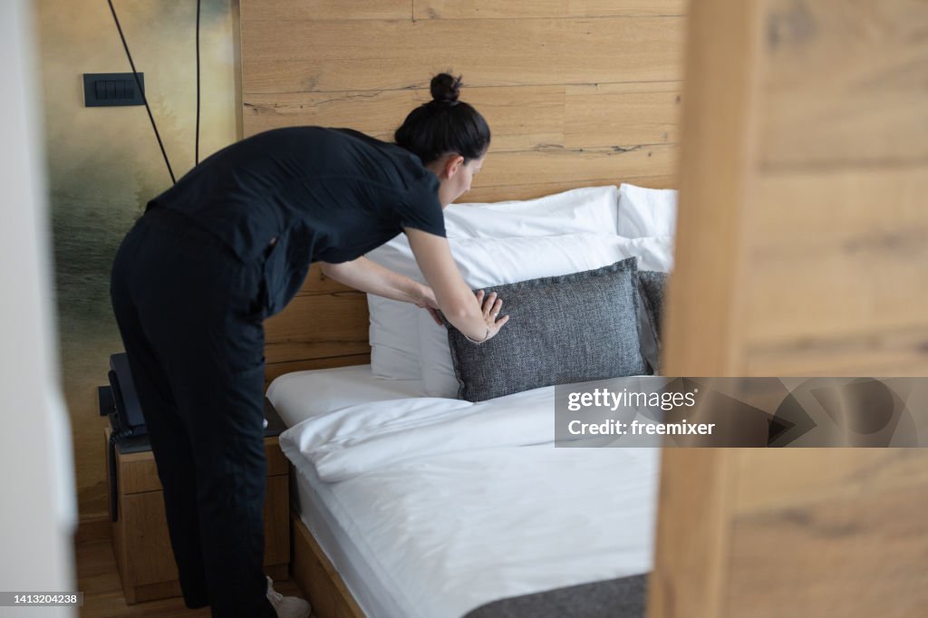 Housekeeper making the bed at a hotel