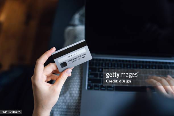 cropped shot of young woman shopping online on laptop at home, entering credit card information to make mobile payment online. lifestyle and e-commerce concept. convenience and easy online shopping experience - bank fraud stock pictures, royalty-free photos & images