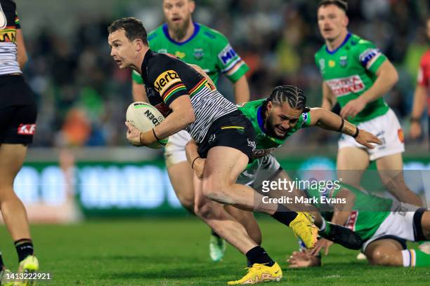 Dylan Edwards of the Panthers is tackled during the round 21 NRL match between the Canberra Raiders and the Penrith Panthers at GIO Stadium, on...