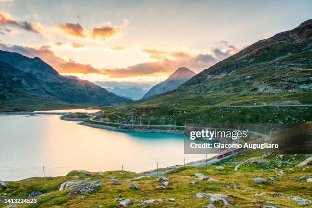 iconic red swiss train at lago bianco, bernina pass,  canton of graubünden - railway tracks sunset stock pictures, royalty-free photos & images