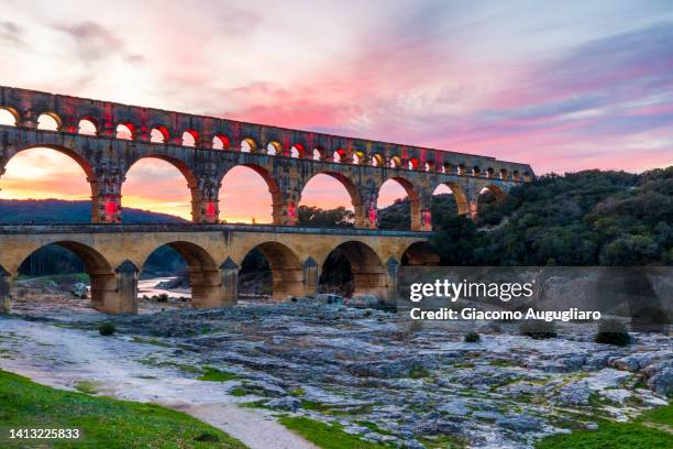 the pont du gard at sunset - famous ancient roman aqueduct crosses gardon river, southern france - pont du gard aqueduct stock pictures, royalty-free photos & images