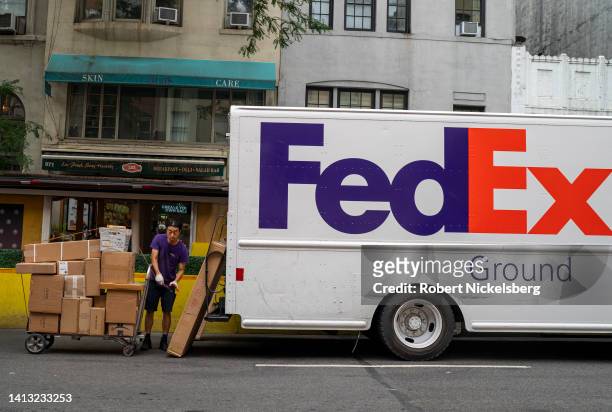FedEx employee loads a cart with packages for deliveries August 5, 2022 in New York City.