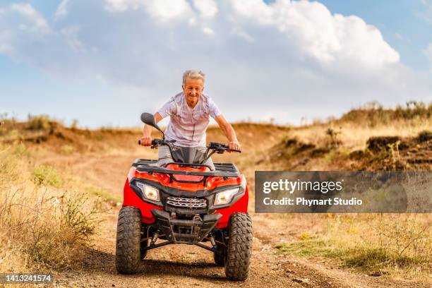 hombre mayor conduciendo quad - adrenalina fotografías e imágenes de stock