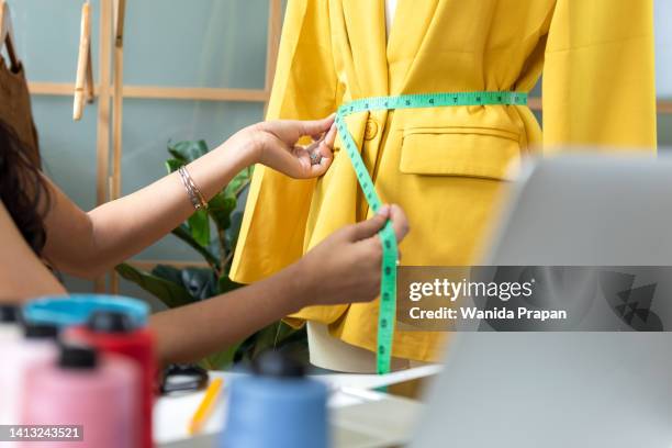 close up hands designer work designer fashion in the showroom. mannequins stylish tailor measurements and cloth rail background. business small concept - measuring stock pictures, royalty-free photos & images