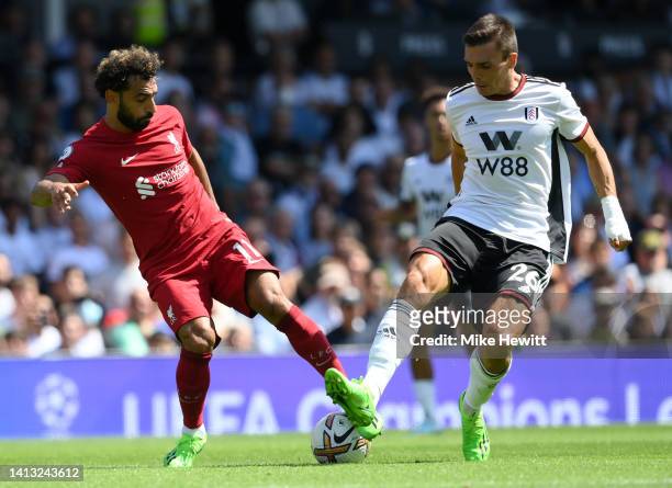Mohamed Salah of Liverpool is challenged by Joao Palhinha of Fulham during the Premier League match between Fulham FC and Liverpool FC at Craven...