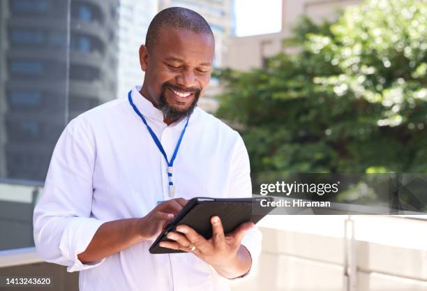 smiling, confident and professional business man browsing on a tablet outside. happy and corporate male scrolling while standing on a balcony. mature senior executive guy checking an email online - looking over balcony stock pictures, royalty-free photos & images