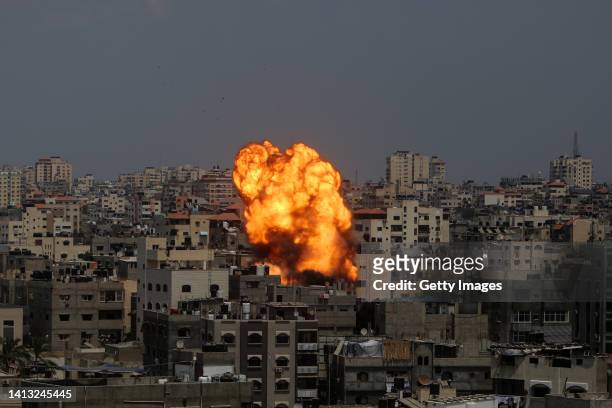 Flames and smoke rise from a residential building following an Israeli airstrike on August 06, 2022 in Gaza City, Gaza. More than ten people have...