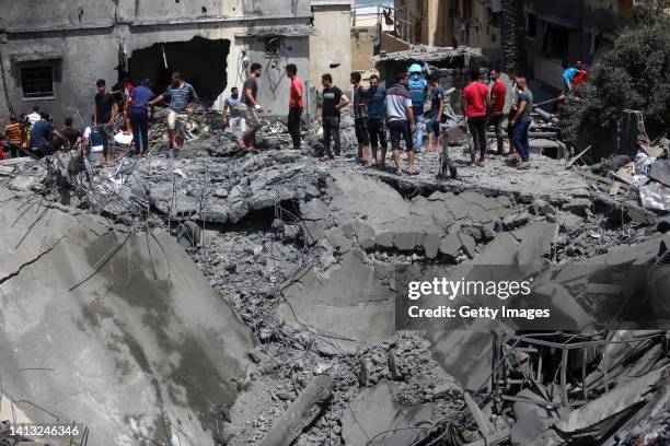 People inspect the rubble of a residential building destroyed by an Israeli airstrike on August 06, 2022 in Gaza City, Gaza. More than ten people...