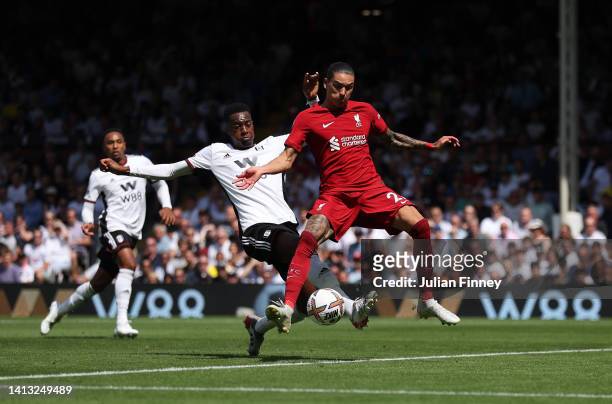 Darwin Nunez of Liverpool scores their side's first goal whilst under pressure from Tosin Adarabioyo of Fulham during the Premier League match...