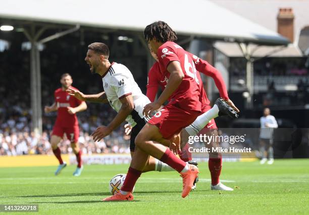 Aleksandar Mitrovic of Fulham is fouled whilst being challenged by Virgil van Dijk and Trent Alexander-Arnold of Liverpool, which results in a...