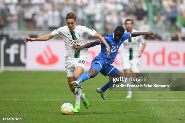 Florian Neuhaus of Borussia Monchengladbach is challenged by Diadie Samassekou of TSG 1899 Hoffenheim during the Bundesliga match between Borussia...