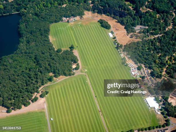 high angle aerial view of traditional english polo club and or racecourse with green fields looking beautiful in the summer sun - polo field stock pictures, royalty-free photos & images