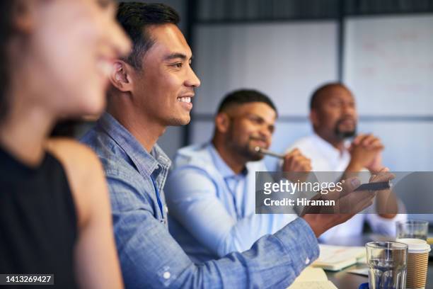young business people having a meeting in a modern office. group of smiling employees in a conference workshop or seminar engaging in team training and coaching at the workplace. - business people cheering in office stockfoto's en -beelden