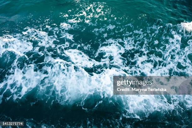 aerial view of the waves in the ocean splashing waves. blue clear wavy sea water. - tide stock pictures, royalty-free photos & images