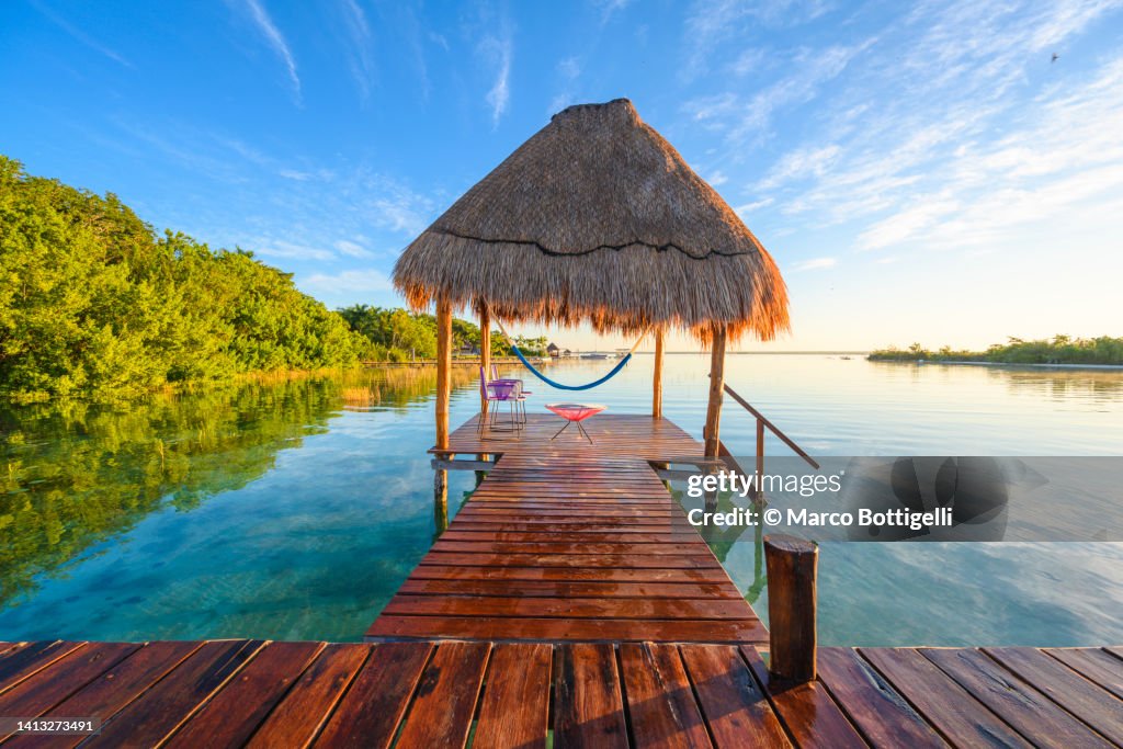 Palapa on wooden pier above the water