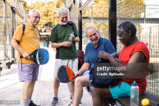 happy senior friends meeting to play padel - diverse mature men stock pictures, royalty-free photos & images
