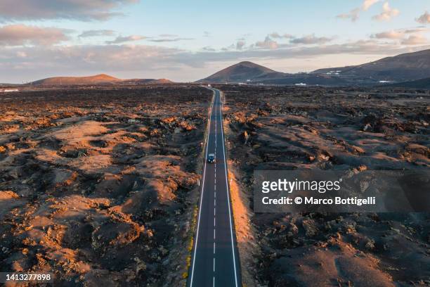 aerial view of straight road among volcanic landscape. lanzarote, spain - lanzarote stock pictures, royalty-free photos & images
