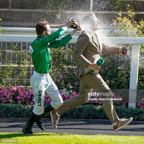 Jockey Jamie Spencer chases Matt Chapman around the parade ring spraying Champagne at him during The Shergar Cup at Ascot Racecourse on August 06,...