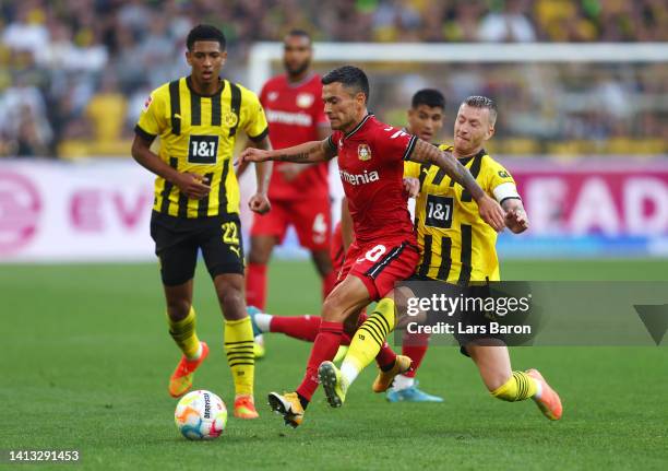 Charles Aranguiz of Bayer Leverkusen is challenged by Marco Reus of Borussia Dortmund during the Bundesliga match between Borussia Dortmund and Bayer...