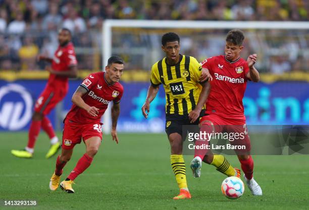 Jude Bellingham of Borussia Dortmund is challenged by Adam Hlozek of Bayer Leverkusen during the Bundesliga match between Borussia Dortmund and Bayer...