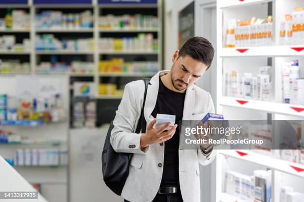 not sure which of these pills are better - man choosing stock pictures, royalty-free photos & images