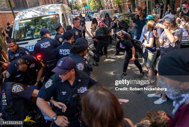 Pro-abortion rights protesters confront New York Police Department officers while arrests are being made, left, outside of a Catholic church in...