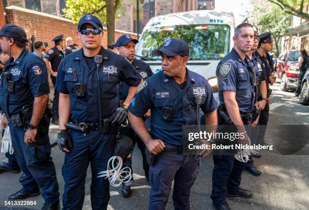 New York Police Department officers protect a police van after Pro-abortion rights protesters were arrested outside of a Catholic church in downtown...