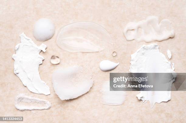 set of cosmetic smears applied on beige background. cleansing foam, lotions, scrubs, gels and moisturizing creams. beauty products with ceramides, polyglutamic acid and beneficial oils. flat lay style - conditioner stock pictures, royalty-free photos & images