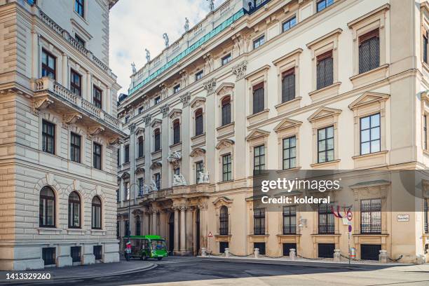 historic center of vienna, classic european architecture street with small green tourists bus - wiener innenstadt stock-fotos und bilder