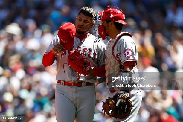 Jaime Barria and Kurt Suzuki of the Los Angeles Angels talk during the third inning against the Seattle Mariners at T-Mobile Park on August 06, 2022...