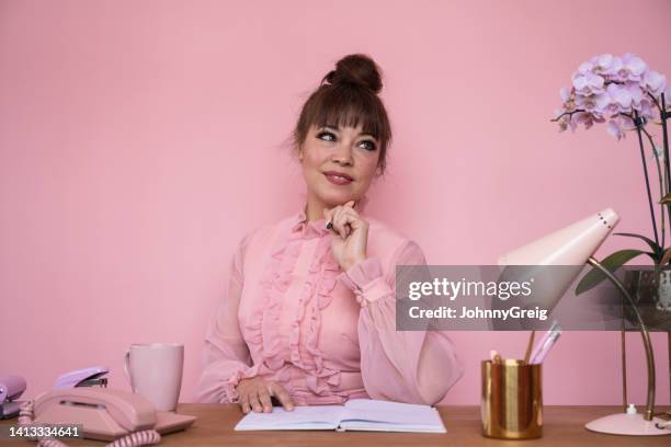 retrato de mujer de negocios con blusa con volantes sentada en el escritorio - red blouse fotografías e imágenes de stock