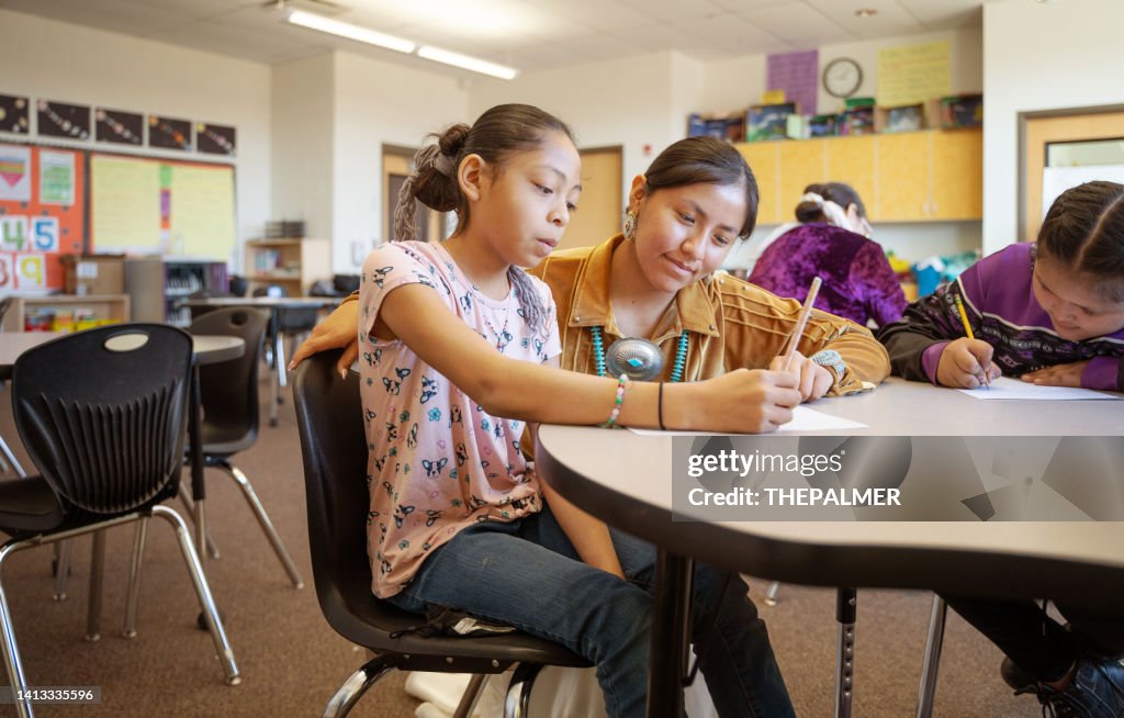 Young indigenous Navajo Young teacher checking her students class work