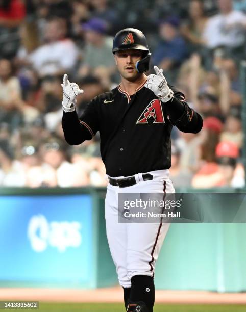 Christian Walker of the Arizona Diamondbacks gestures to his bench after hitting an RBI single against the Colorado Rockies during the first inning...
