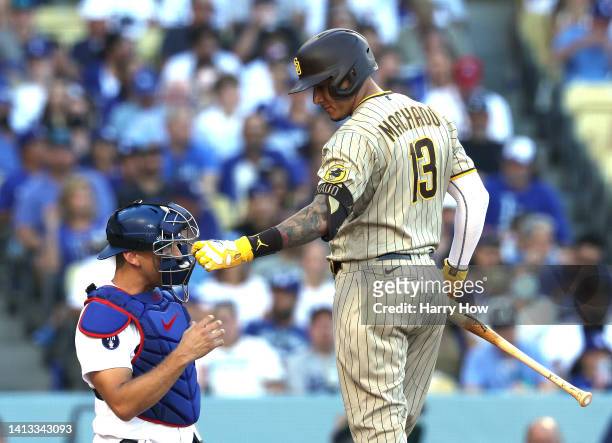 Manny Machado of the San Diego Padres plays with the mask of Austin Barnes of the Los Angeles Dodgers during the first inning at Dodger Stadium on...