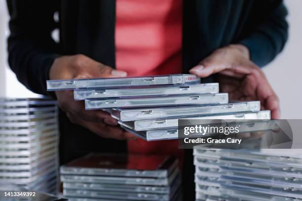 woman sorts her cd collection - compact disc fotografías e imágenes de stock