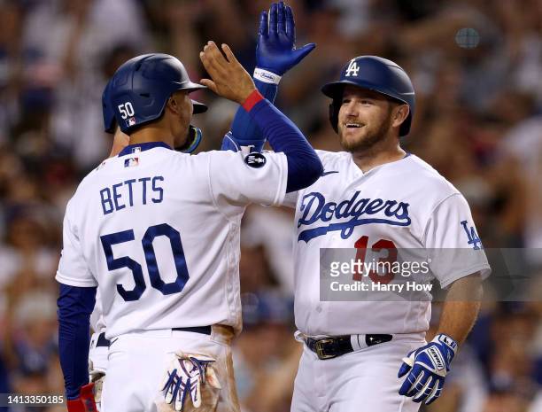 Max Muncy of the Los Angeles Dodgers celebrates his three run homerun with Mookie Betts, to take a 5-3 lead over the San Diego Padres, during the...