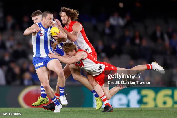 Luke Davis-Uniake of the Kangaroos breaks the tackle of Callum Mills of the Swans during the round 21 AFL match between the North Melbourne Kangaroos...