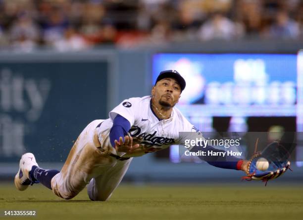 Mookie Betts of the Los Angeles Dodgers makes a diving attempt to catch a ball off the bat of Manny Machado of the San Diego Padres during the eighth...