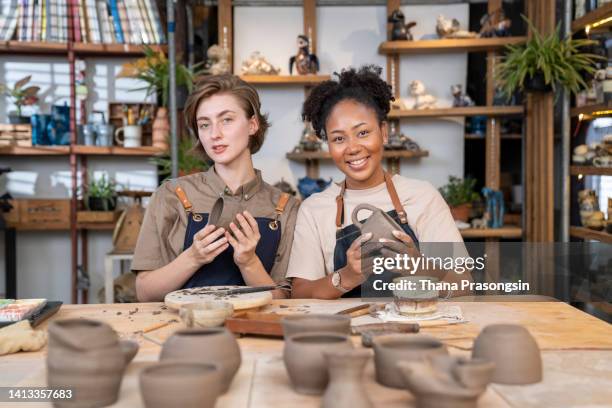 happy young woman making a ceramic pot in a pottery workshop. - craft show stock pictures, royalty-free photos & images