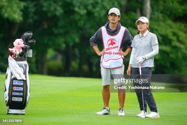 Sakura Yokomine of Japan talks with her caddie and husband Yotaro Morikawa on the 15th hole during the final round of Hokkaido meiji Cup at Sapporo...