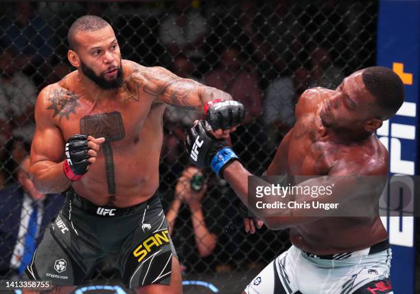 Thiago Santos of Brazil punches Jamahal Hill in a light heavyweight fight during the UFC Fight Night event at UFC APEX on August 06, 2022 in Las...