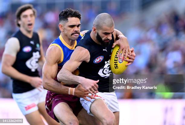 Adam Saad of the Blues is pressured by the defence of Charlie Cameron of the Lions during the round 21 AFL match between the Brisbane Lions and the...