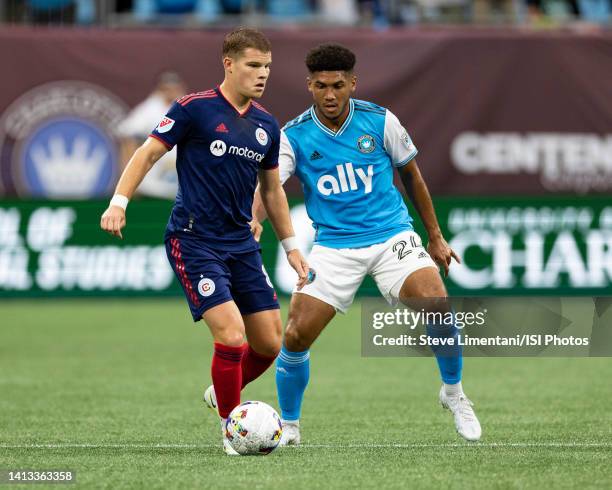 Chris Mueller of Chicago Fire passes the ball away from a challenge by Jaylin Lindsey of Charlotte FC during a game between Chicago Fire FC and...